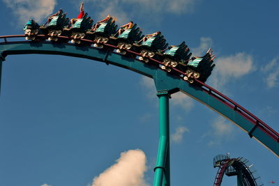 Low angle view of chain swing ride against sky