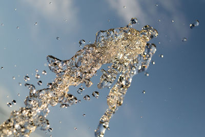 Close-up of water splashing on lake against sky