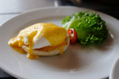 Close-up of food in plate on table. plain egg benedict with pepper seasoning