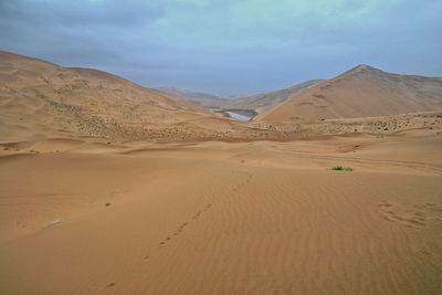 1054 unidentified lake mirrors a megadune of the badain jaran-gobi desert. inner mongolia-china.