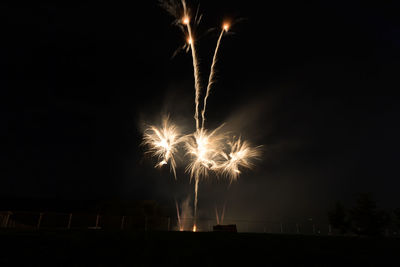 Low angle view of firework display at night