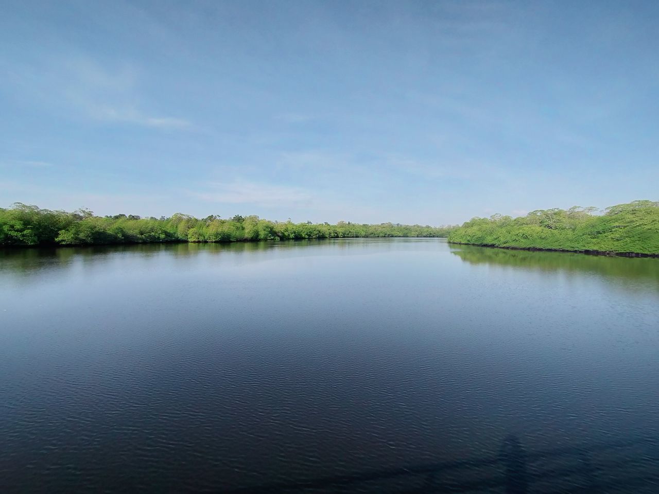 water, reflection, sky, scenics - nature, tranquility, beauty in nature, lake, nature, tranquil scene, reservoir, body of water, no people, tree, plant, landscape, environment, cloud, non-urban scene, day, blue, outdoors, land, shore, idyllic, travel destinations, horizon, copy space, morning, natural environment, wetland, green