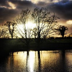 Scenic view of river against cloudy sky