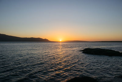 Scenic view of sea against clear sky during sunset