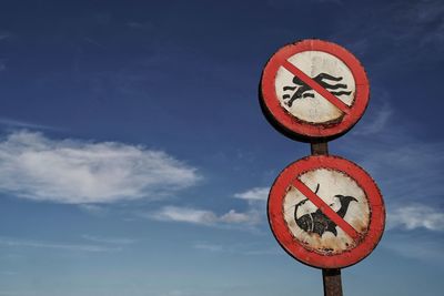 Low angle view of road sign against sky