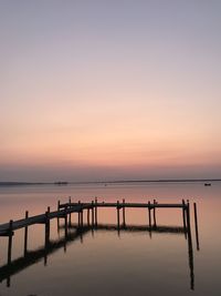 Pier over sea against sky during sunset