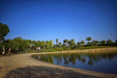 Scenic view of lake against clear blue sky