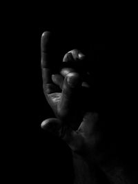 Close-up of hand over black background