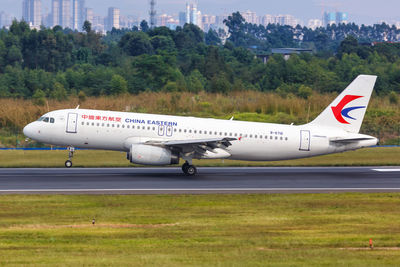 Side view of airplane on airport runway against sky