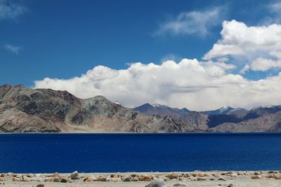 Scenic view of lake against mountains and blue sky