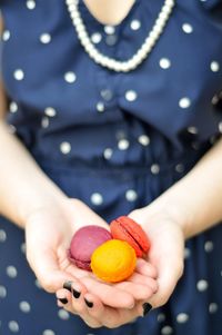 Midsection of woman holding macaroons