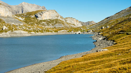 Scenic view of sea and mountains against clear blue sky