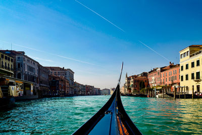 Canal amidst buildings in city against sky