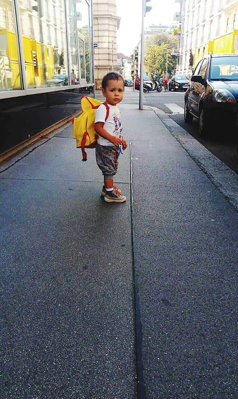 transportation, childhood, person, street, full length, lifestyles, casual clothing, land vehicle, elementary age, innocence, boys, mode of transport, leisure activity, car, portrait, front view, looking at camera, cute