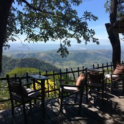 Chairs and table on landscape against mountains