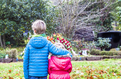 Rear view of boy standing against plants