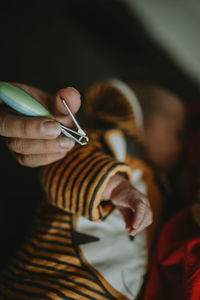 Cropped hand of woman holding baby at home