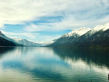 Scenic view of lake and snowcapped mountains against sky