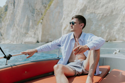 Portrait of a young man drinking champagne in a boat.