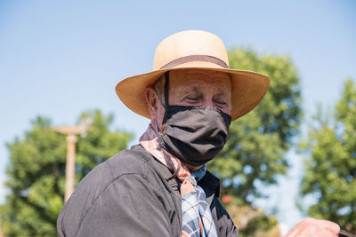 Portrait of elder man wearing hat against sky