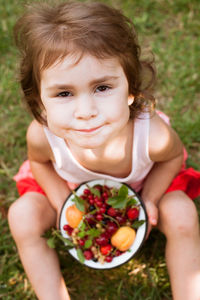 Portrait of baby girl holding fruit