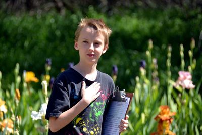 Close-up of boy holding clipboard at park