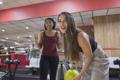 A young woman bowling.