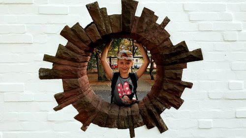 Portrait of girl standing against wall