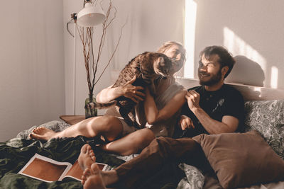 Young couple with dog sitting at home