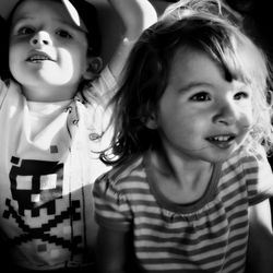 Close-up of cute siblings sitting indoors