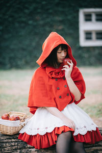 Young woman holding apple and sitting on bench