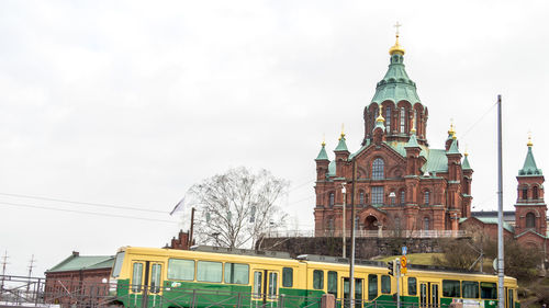 Low angle view of uspenski cathedral by train against sky