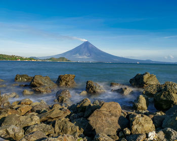 Scenic view of sea and mountains against sky