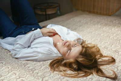Midsection of woman resting on bed at home