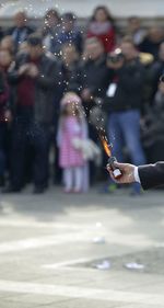 Close-up of hand holding firework on road