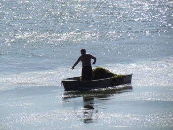 Silhouette man on boat in sea