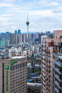 Buildings in city against cloudy sky