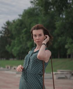 Young woman standing on tree against sky