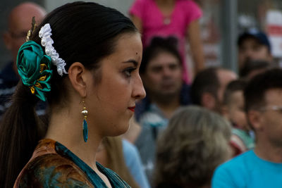 Side view of young woman wearing earring and hair accessory outdoors