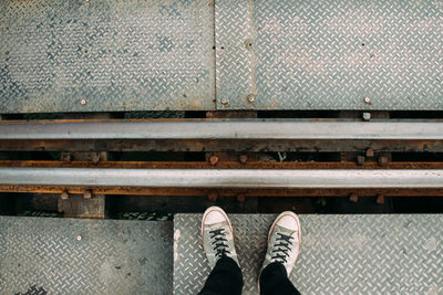 Low section of man standing on railroad station platform