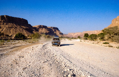 Car moving on road along desert