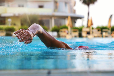 Reflection of man swimming in pool