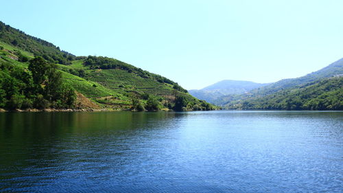 Scenic view of lake and mountains against clear sky