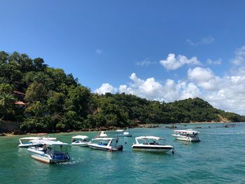 Boats moored on sea against sky