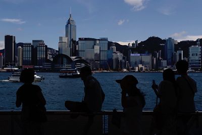 Silhouette of men with cityscape in background