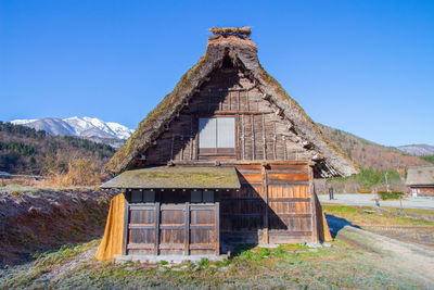 Old building on field against clear blue sky