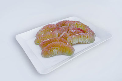 High angle view of fish on plate against white background