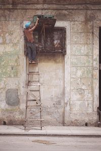 Man standing against brick wall