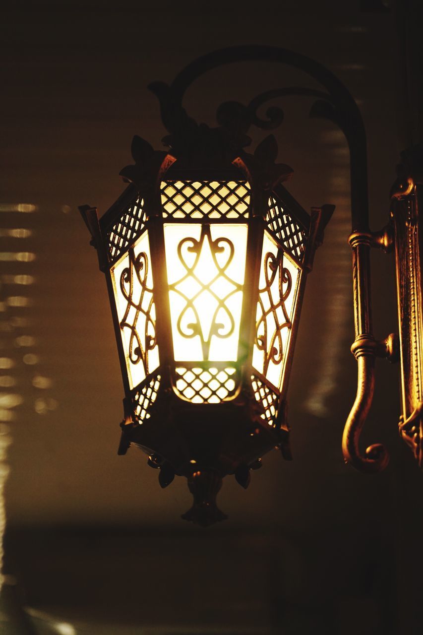 CLOSE-UP OF ILLUMINATED LAMP IN DARKROOM