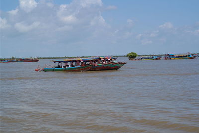 Boats sailing in sea against sky